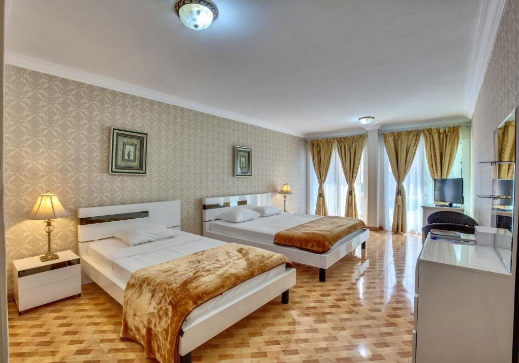 Spacious guest room with two beds and a balcony